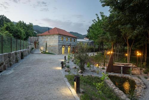 a building with a garden with a pond in front of it at Villas Santo António in Baião