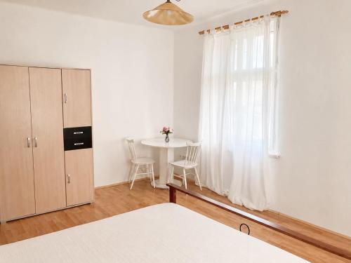 a white room with a table and a window at Apartmán Růžovka in Jaroměř