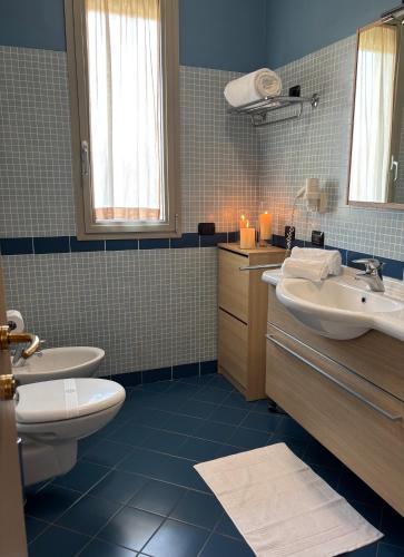 a bathroom with a toilet and a sink and mirror at Hotel Residence Zodiaco in Modena