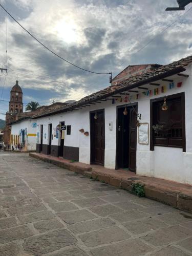 a white building with brown doors on a street at CASA MAGIA by Magally Velasco in Curití