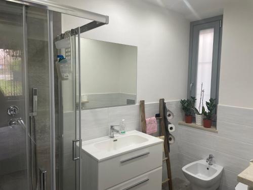 a white bathroom with a sink and a shower at Villa Alessandra in Acqui Terme