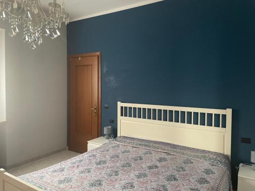 a bedroom with a bed and a blue wall at Villa Alessandra in Acqui Terme