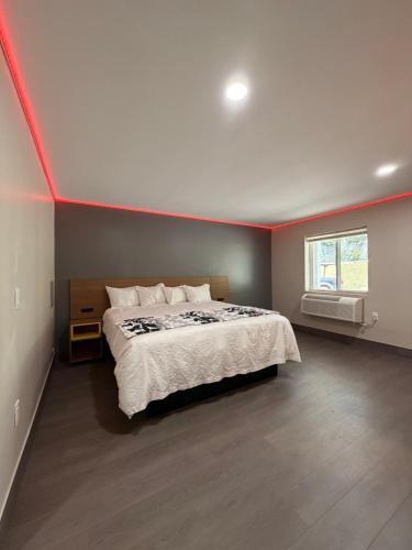 a bedroom with a bed with a red stripe on the wall at Wethersfield Motel in Wethersfield