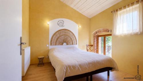 a bedroom with a large bed in a room at L'Hirondelle des Sarments in Montaigut-le-Blanc