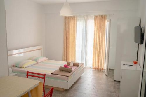 a small bedroom with a bed and a window at PortoAgali in Porto Koufo