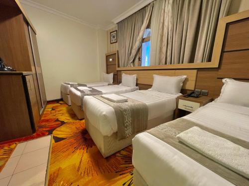 a row of beds in a hotel room at Al Mukhtara Almasi Hotel - شركة المختارة الماسي للخدمات الفندقيه شخص واحد in Medina