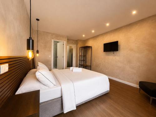 a bedroom with a large white bed and a flat screen tv at Apartments City Center • Collection by Perpetual Relax in Braga