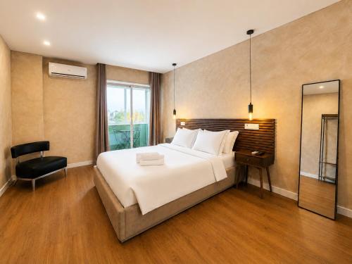 a bedroom with a large white bed and a chair at Apartments City Center • Collection by Perpetual Relax in Braga