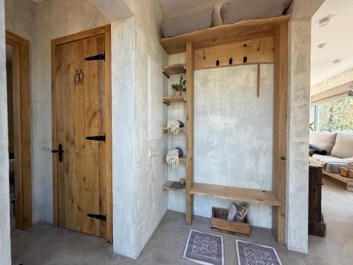 a room with a bed and a wooden door at Nest Spa Mirror Villas in Medemciems