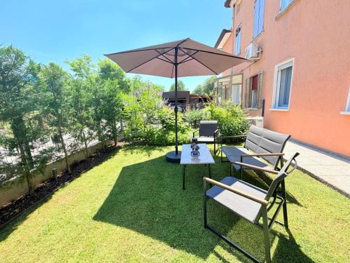 a patio with a table and chairs and an umbrella at Padova Cottage in Padova