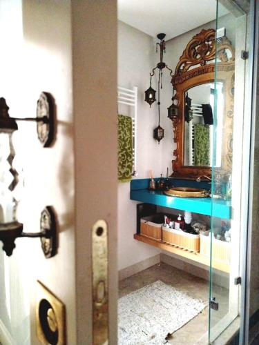 a bathroom with a blue sink and a mirror at Sainte Madeleine in Boumhel El Bassatine