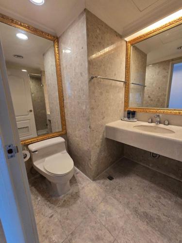 ein Badezimmer mit Toilette, Waschbecken und Spiegel in der Unterkunft Corner Inn in Taichung