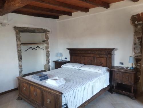 a bedroom with a large bed with a wooden headboard at BeB LORTALLINO in Ameno
