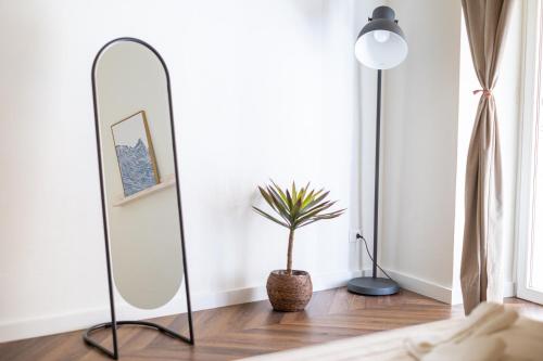 a room with a mirror and a potted plant at BISCOTTAI Port Apartments in Trapani
