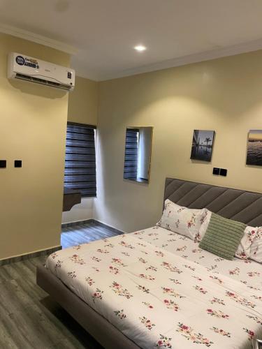 a bedroom with a bed and a air conditioner on the wall at Sandton Luxury Apartment in Bardon Yana