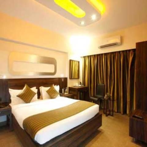 a hotel room with a bed and a desk at Hotel Plaza in Mumbai