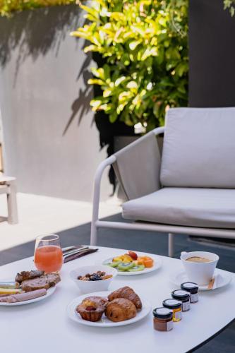 a table topped with plates of food and drinks at Hôtel In Situ in Béziers