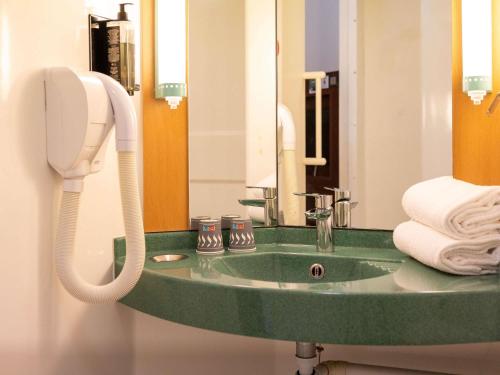 a bathroom with a green sink and a phone at ibis Montauban in Montauban