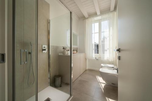 a bathroom with a glass shower and a toilet at Flowers Liberty Suites in Brescia