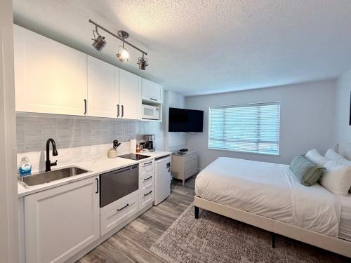 a bedroom with a bed and a sink and a kitchen at Cascade Lodge Studio-steps from village in Whistler