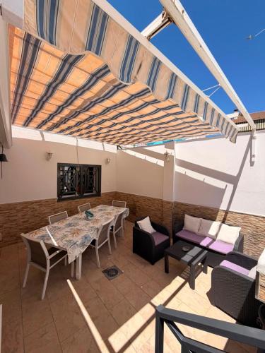 a patio with a table and chairs and a fireplace at Villa Wilecris in Punta Umbría