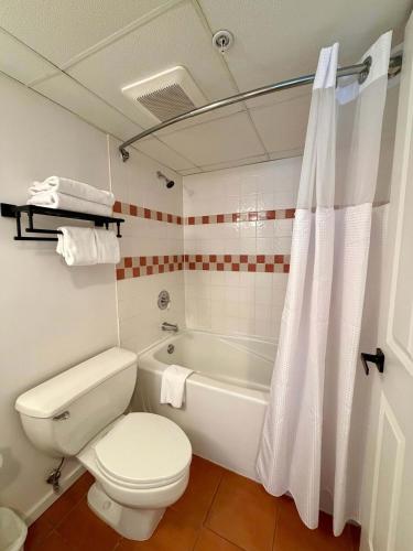 a bathroom with a toilet and a tub and a sink at Cascade Lodge Studio-steps from village in Whistler