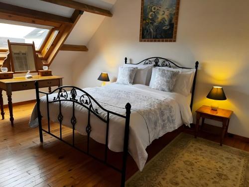 a bedroom with a large bed and a desk at Walnut Tree Gîte in Boderel