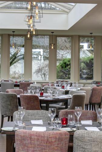 a dining room with tables and chairs with wine glasses at Best Western Plus Dunfermline Crossford Keavil House Hotel in Dunfermline