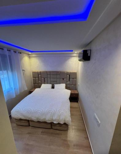 a bedroom with a large bed with a blue ceiling at Appartement Moderne de Standing près de route de casa in Marrakesh