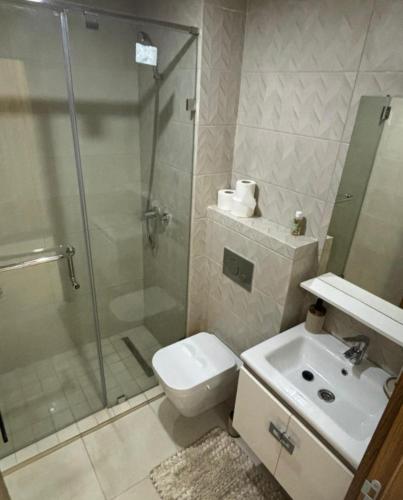 a bathroom with a shower and a toilet and a sink at Appartement Moderne de Standing près de route de casa in Marrakesh
