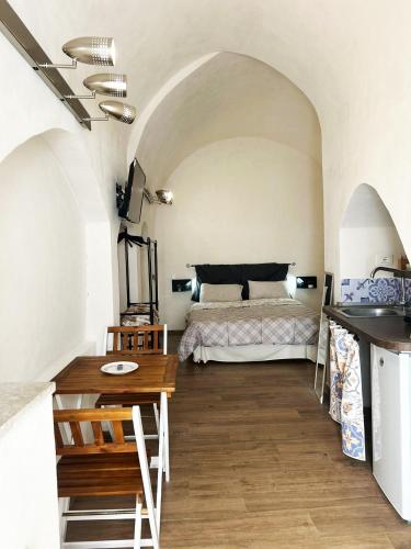 ein Schlafzimmer mit einem Bett und einem Tisch in einem Zimmer in der Unterkunft Maltese16 in Modica