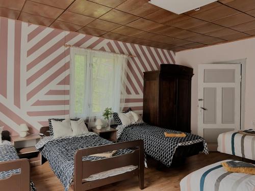 a room with two beds and a striped wall at Viesu nams Kātiņi in Energetikis