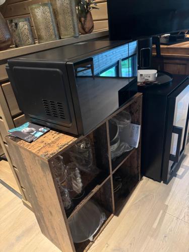 a tv sitting on top of a wooden stand at Rom med eget bad til leie felles inngang Uten kjøkken og stue Kun overnatting in Tjørhom