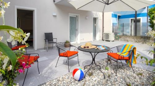 a patio with a table and chairs and an umbrella at Casa Quadrifoglio - Valgrande in Intra