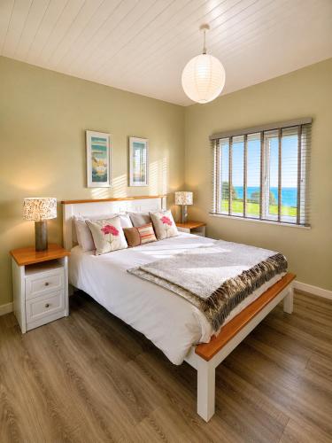a bedroom with a large bed and a window at Dunmore East Ocean View Suite in Dunmore East