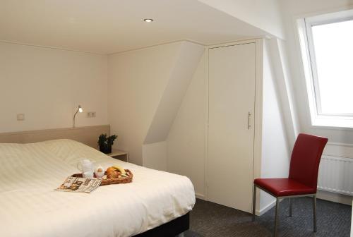 een slaapkamer met een bed met een fruitmand erop bij Kodde Apartments in Aagtekerke