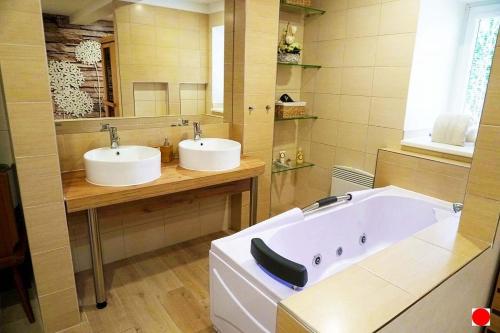 a bathroom with two sinks and a bath tub at Rovenská Chalupa in Strážov