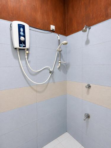 a bathroom with a shower with a soap dispenser on the wall at Sigiri Lion Lodge in Sigiriya