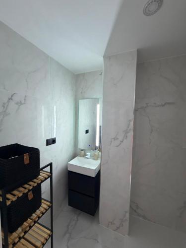a white bathroom with a sink and a mirror at Punta Prima Sun & Sea Apartament in Punta Prima