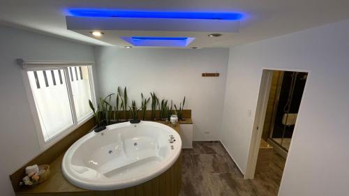 a large bath tub in a bathroom with a blue ceiling at Grateus Apart in Villa General Belgrano
