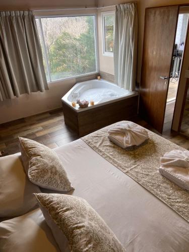 a bedroom with a large bed and a bath tub at Grateus Apart in Villa General Belgrano