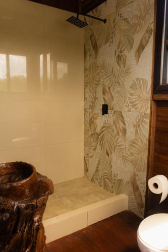 a bathroom with a shower with a toilet at Paraíso Nimah in Flores