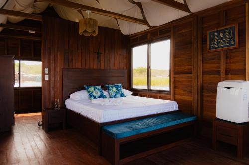 a bedroom with a bed in a wooden room at Paraíso Nimah in Flores