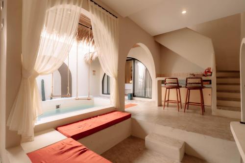 a living room with a large window and a table at Maroko Jogja Villas With Privatepool in Ngaglik