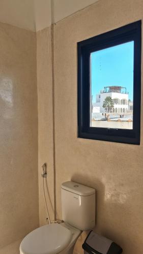 a bathroom with a toilet and a window at Rumah Merta Sari in Bingin Beach