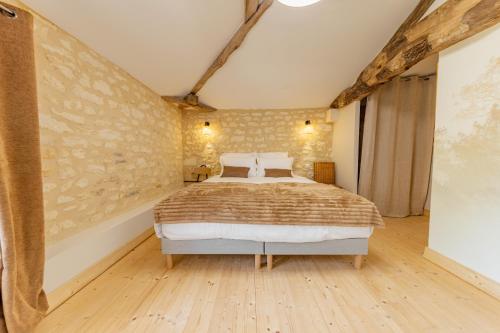 a bedroom with a large bed in a room at La Châtellerie du Gagnon in Champagnolles