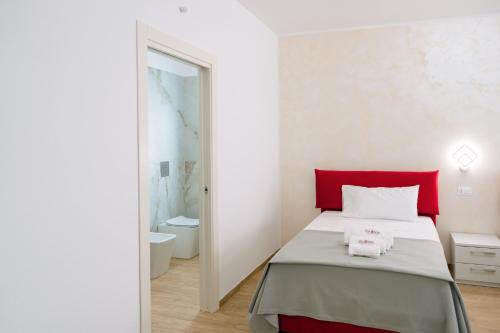 a bedroom with a bed with a red headboard and a mirror at B&B Da Anna in Torretta