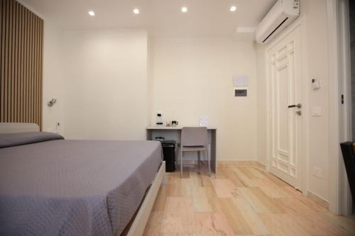 a bedroom with a bed and a desk and a table at Dimora del mare in Agropoli
