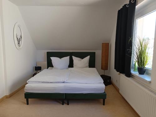 a bedroom with a bed with white sheets and a window at Isabella in Weißwasser
