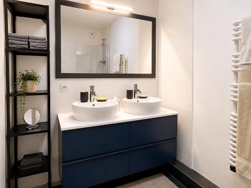 a bathroom with two sinks and a mirror at Le Penthouse de Levallois in Levallois-Perret